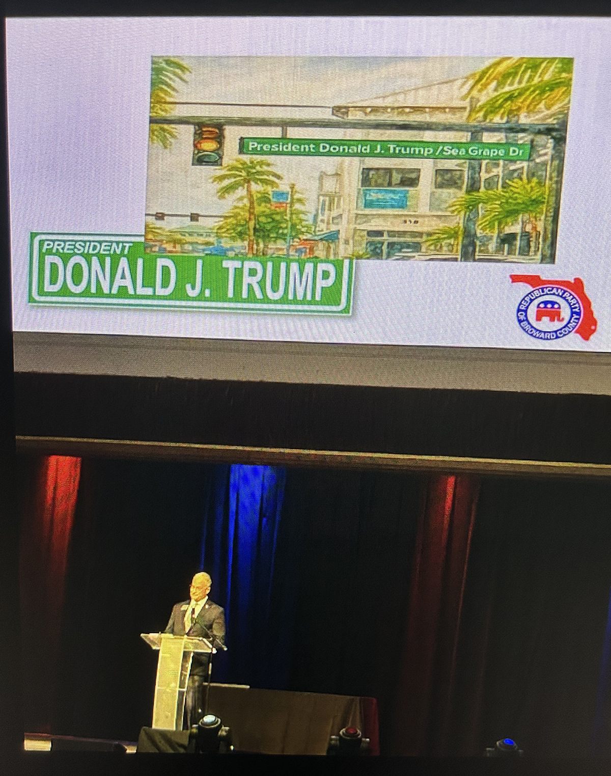 The party's slide at its September 13, 2025 event: the Sea Grape Drive sign with the party logo